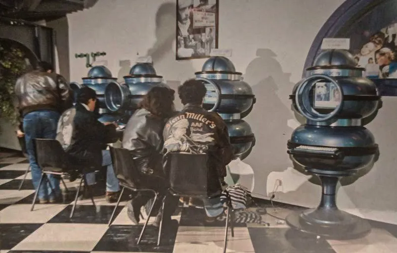 Ragazzi seduti ai terminali Dialogos in un locale, primi anni '90